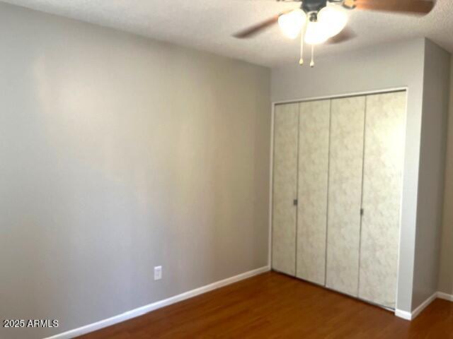 unfurnished bedroom with a closet, ceiling fan, and hardwood / wood-style flooring