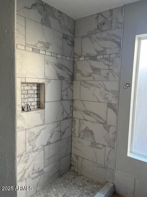 bathroom featuring a tile shower