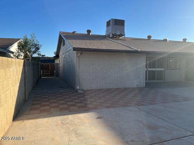 rear view of property featuring central AC and a patio area