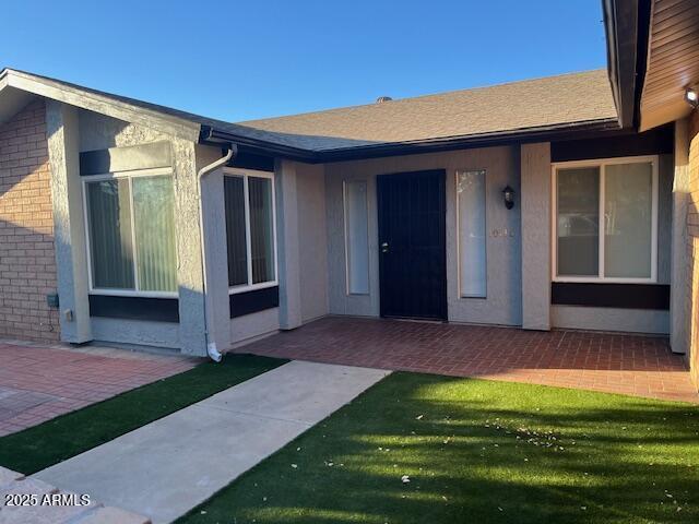 property entrance with a patio area and a yard