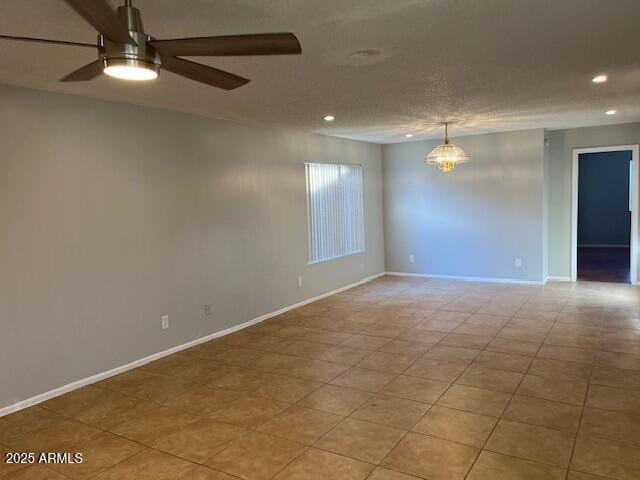 spare room with ceiling fan with notable chandelier and light tile patterned floors