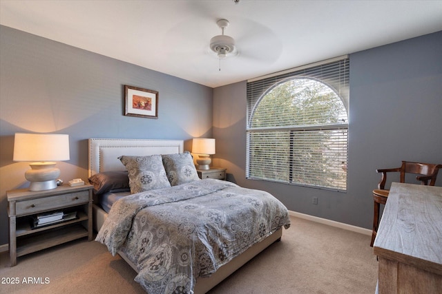 carpeted bedroom featuring baseboards and a ceiling fan