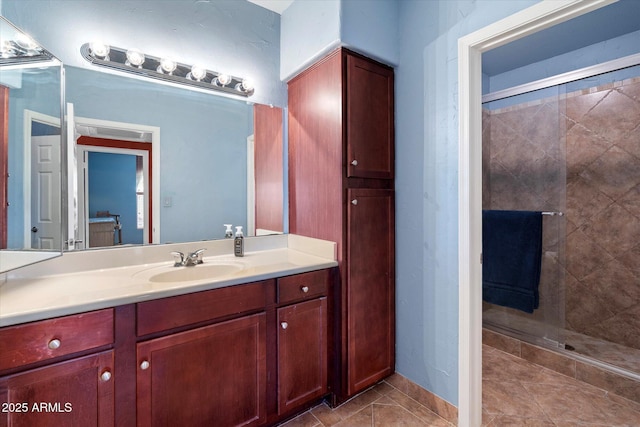 full bath with tile patterned floors, vanity, and tiled shower