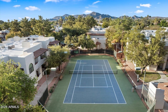 view of tennis court with fence and a mountain view