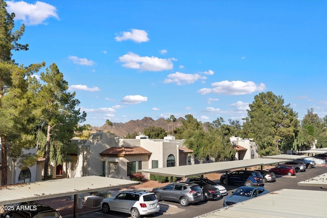 partially covered parking lot featuring a mountain view