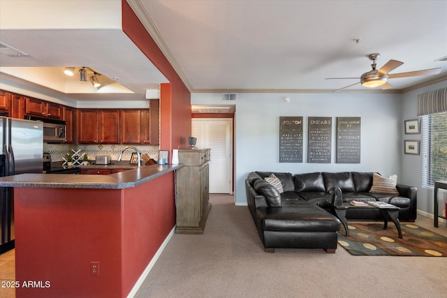 kitchen with open floor plan, stainless steel appliances, dark countertops, ceiling fan, and visible vents