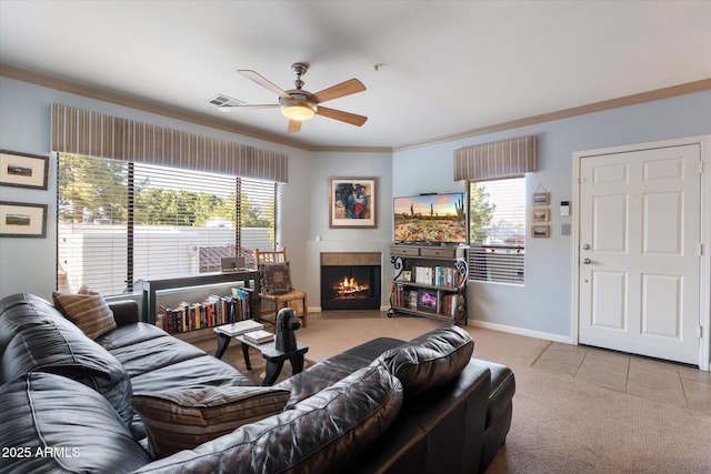 carpeted living area featuring plenty of natural light, baseboards, crown molding, and ceiling fan