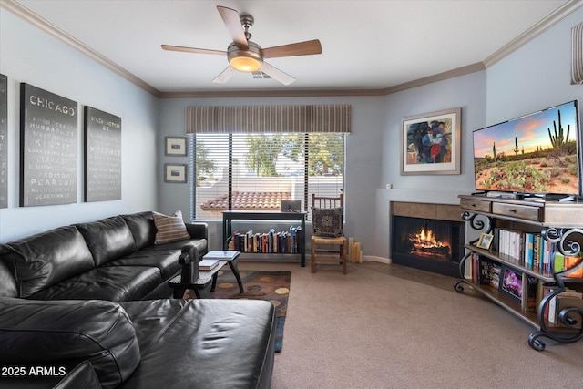living room featuring carpet, baseboards, a fireplace, ornamental molding, and ceiling fan