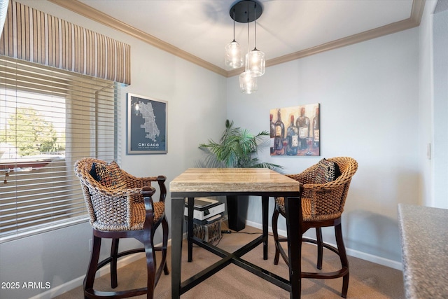 carpeted dining area with baseboards and crown molding