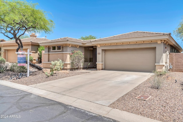 view of front facade featuring a garage, concrete driveway, a tiled roof, and stucco siding