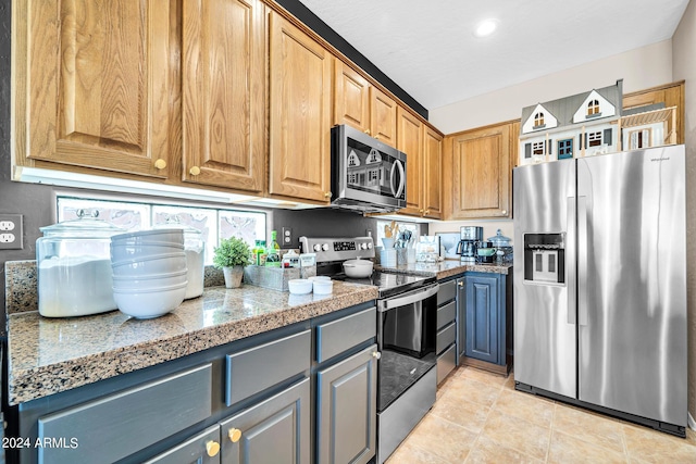 kitchen with tile countertops, light tile patterned floors, and stainless steel appliances