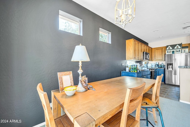 dining room with a chandelier and a textured wall