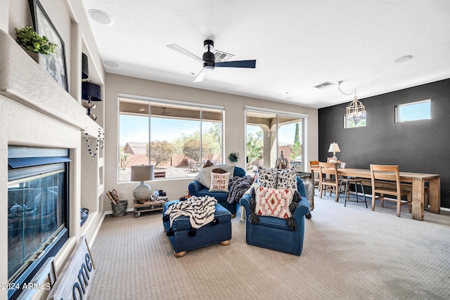 living room featuring carpet, visible vents, a ceiling fan, a glass covered fireplace, and baseboards