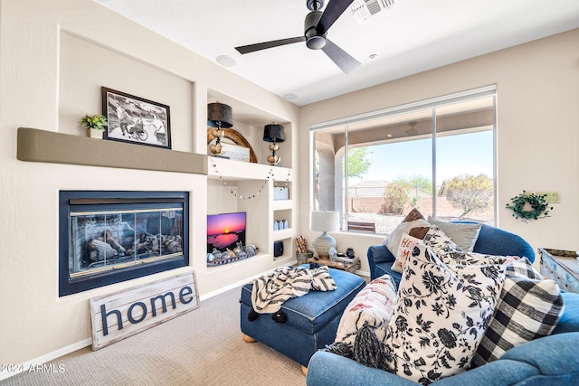 carpeted living room with baseboards, a fireplace, visible vents, and ceiling fan