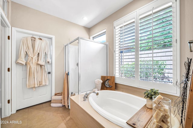 full bath featuring a stall shower, tile patterned flooring, a garden tub, and a wealth of natural light