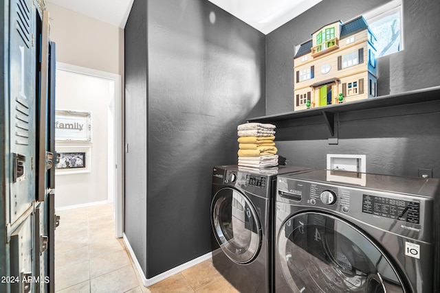 washroom with light tile patterned floors, a textured wall, separate washer and dryer, laundry area, and baseboards