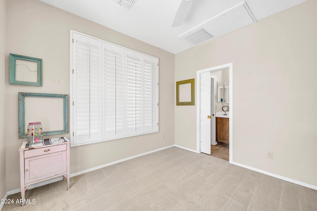 bedroom with baseboards, visible vents, a ceiling fan, light colored carpet, and ensuite bath