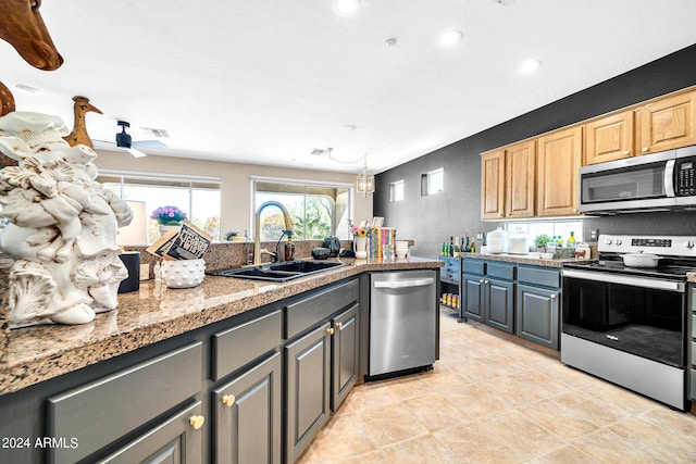 kitchen with a textured wall, stainless steel appliances, a sink, visible vents, and tile counters