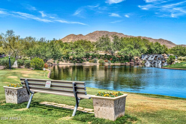 view of community with a lawn and a water and mountain view