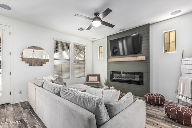 3109 N Black Rock Rd, Buckeye, AZ 85396 - living room featuring ceiling fan, a fireplace, dark wood-style floors, and baseboards