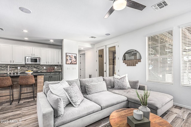 3109 N Black Rock Rd, Buckeye, AZ 85396 - living room featuring light wood finished floors, a ceiling fan, recessed lighting, french doors, and baseboards