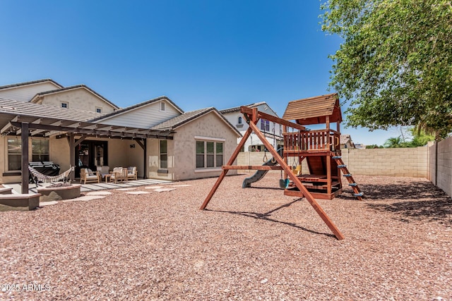 3109 N Black Rock Rd, Buckeye, AZ 85396 - rear view of house featuring a fenced backyard, an outdoor living space with a fire pit, a playground, stucco siding, and a patio