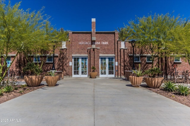 3109 N Black Rock Rd, Buckeye, AZ 85396 - rear view of house featuring french doors, brick siding, and a chimney