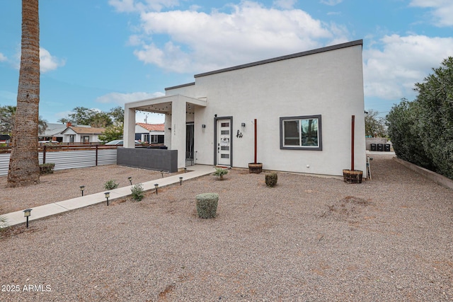 view of front of house with fence and stucco siding