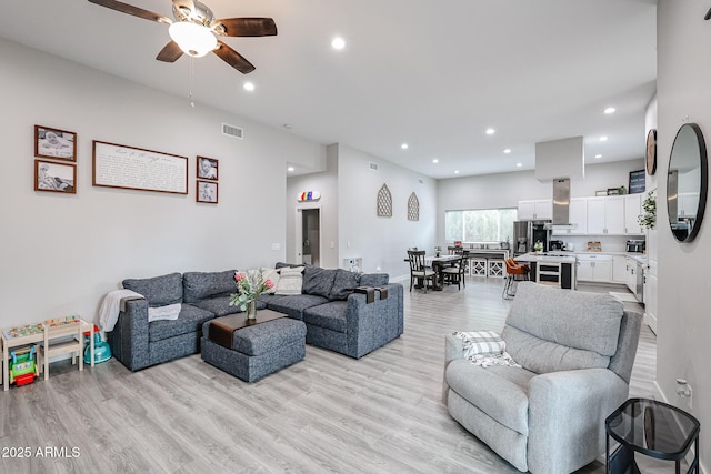 living area with ceiling fan, recessed lighting, visible vents, baseboards, and light wood finished floors