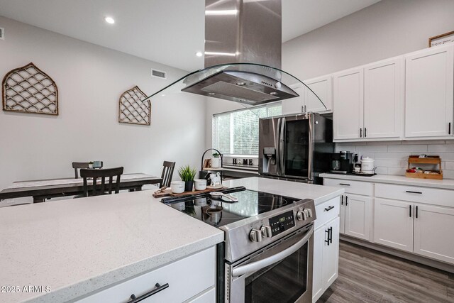 kitchen with white cabinetry, fridge with ice dispenser, island exhaust hood, and stainless steel range with electric cooktop