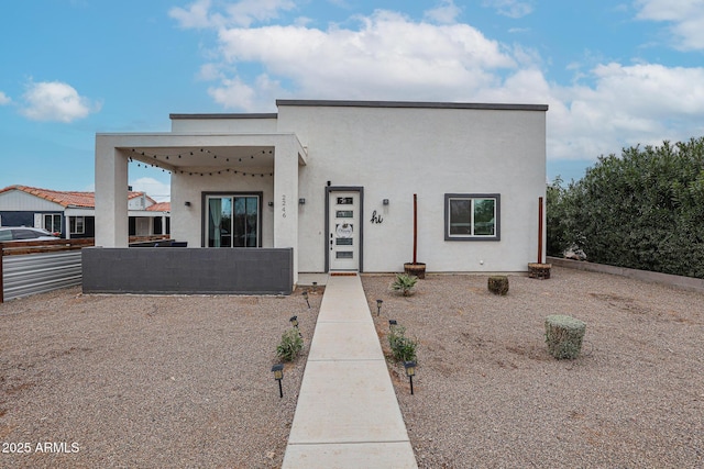 view of front of property with fence and stucco siding