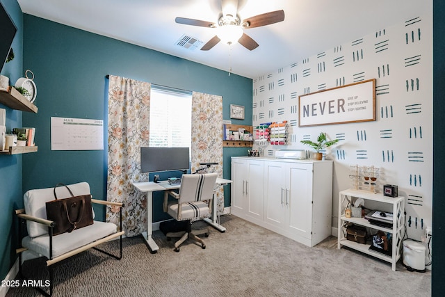 office featuring light carpet, visible vents, and a ceiling fan