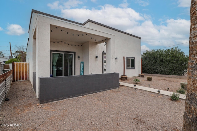 view of front of home featuring fence and stucco siding