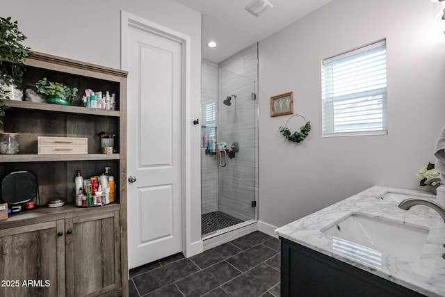 full bathroom featuring a stall shower, a sink, baseboards, and tile patterned floors