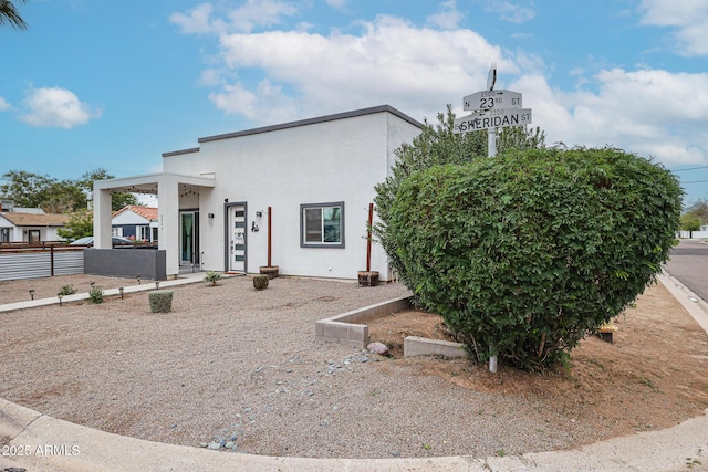 view of front facade featuring fence and stucco siding