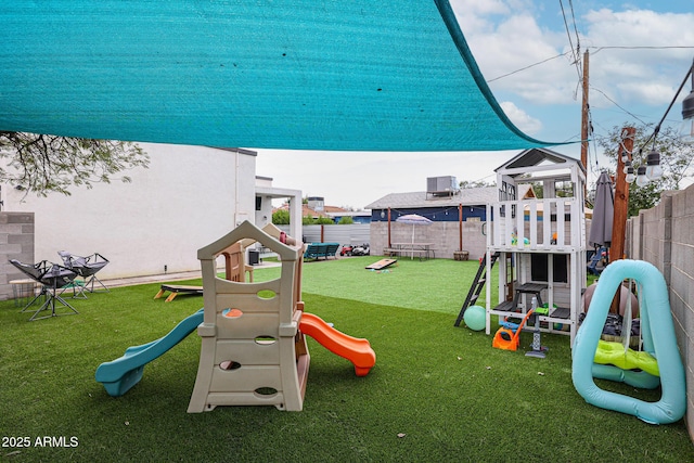 view of playground featuring a lawn and a fenced backyard