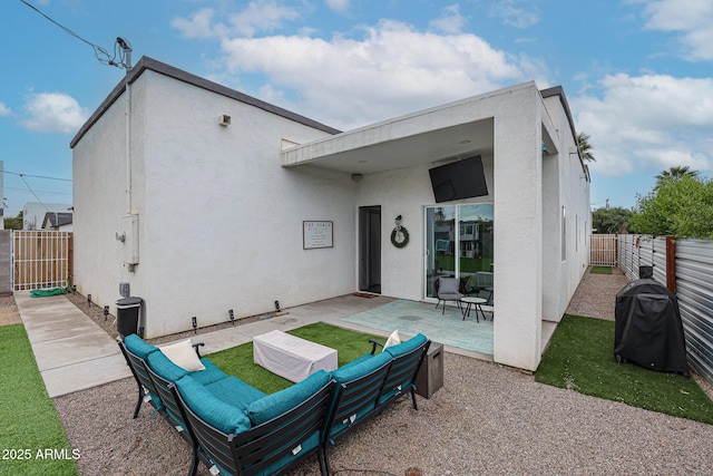 rear view of house featuring stucco siding, a fenced backyard, and a patio