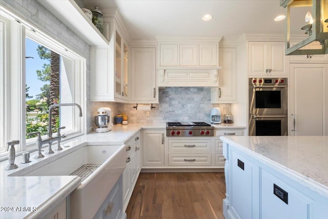 kitchen featuring appliances with stainless steel finishes, hanging light fixtures, white cabinetry, and a healthy amount of sunlight