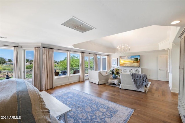 bedroom featuring ornamental molding, wood-type flooring, and an inviting chandelier