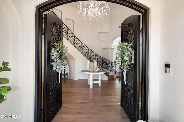 entryway featuring dark hardwood / wood-style flooring, a notable chandelier, and crown molding