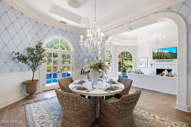 dining room featuring a healthy amount of sunlight, a tray ceiling, and a notable chandelier