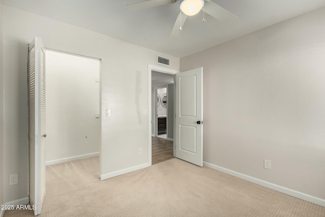 unfurnished bedroom with light colored carpet and ceiling fan