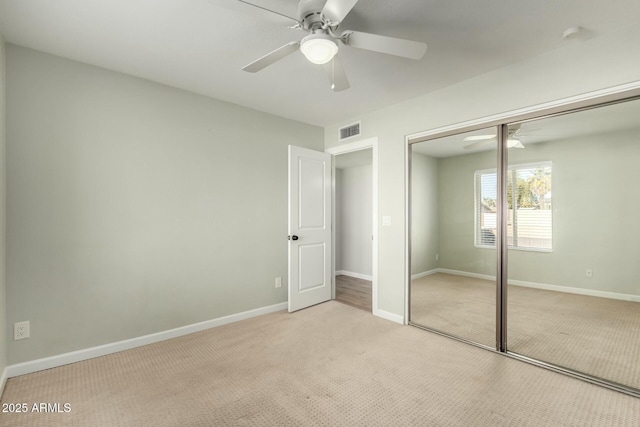 unfurnished bedroom with ceiling fan, a closet, and light carpet