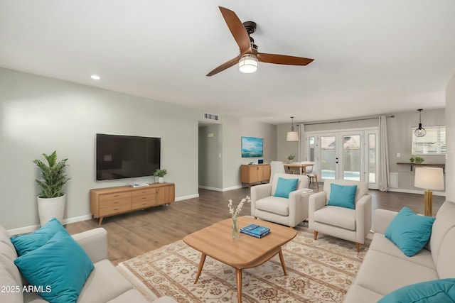 living room with hardwood / wood-style flooring, french doors, and ceiling fan