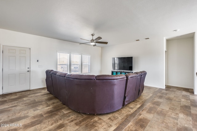 living room featuring a textured ceiling, dark hardwood / wood-style floors, and ceiling fan