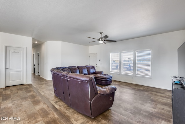 living room with a textured ceiling, wood-type flooring, and ceiling fan