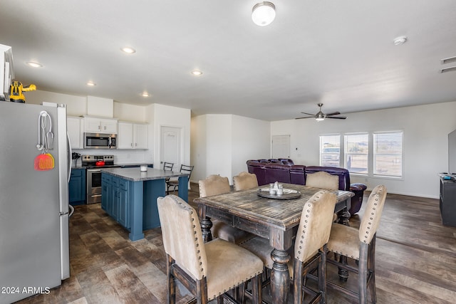 dining space with ceiling fan and dark hardwood / wood-style flooring