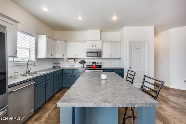 kitchen featuring a kitchen island, dark wood-type flooring, sink, white cabinetry, and appliances with stainless steel finishes