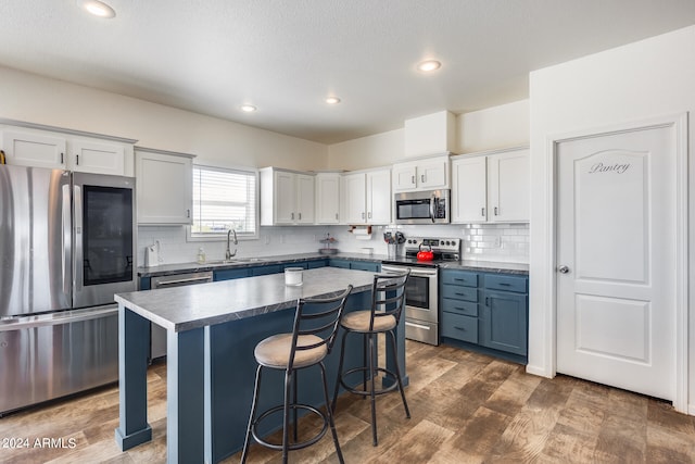 kitchen featuring a kitchen island, a kitchen breakfast bar, dark hardwood / wood-style floors, sink, and stainless steel appliances