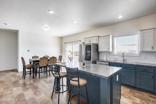 kitchen featuring hardwood / wood-style flooring, stainless steel appliances, sink, and a kitchen island